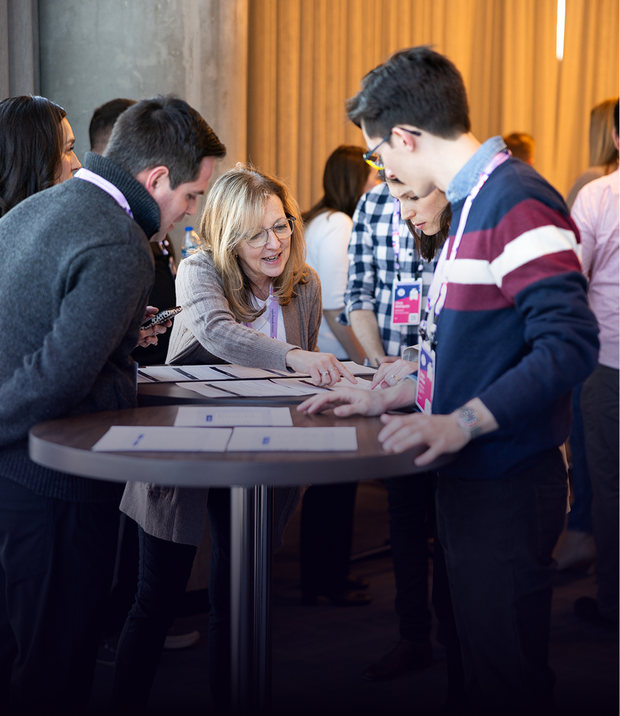 Conference attendees collaborating around table during workshop activity